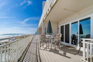 einen Balkon mit Tischen und Stühlen sowie Strand in der Unterkunft Turtle Ridge in Pensacola Beach