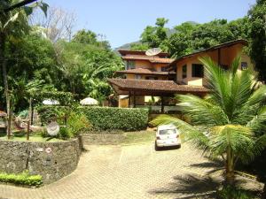 a white car parked in front of a house at Vila São Pedro in Ilhabela