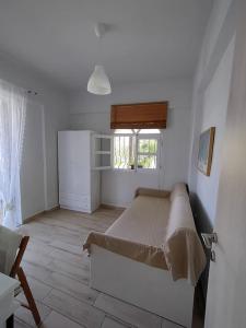a white bedroom with a bed and a window at O&A By the Sea in Polykhrono
