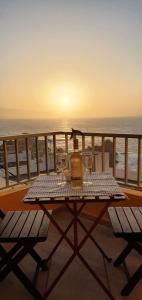 un tavolo con una bottiglia di vino e bicchieri sul balcone di Disfruta del mar a El Pris