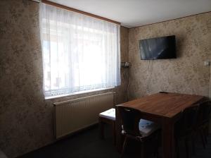 a room with a table and a television and a window at Holiday Home Over The River in Bovec