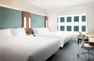a hotel room with two beds and a chair at LUMA Hotel San Francisco - #1 Hottest New Hotel in the US in San Francisco