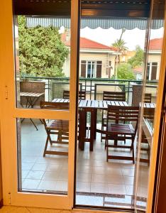 een glazen schuifdeur met een tafel en stoelen op een balkon bij Casa Ginestra Mare in Bordighera