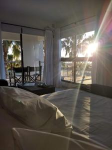 sypialnia z łóżkiem ze słońcem świecącym przez okno w obiekcie Andaluhe Posada w Miramar (w prowincji Córdoba)