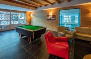 a billiard room with a pool table and chairs at La foux d allos Superbe appartement 6 couchages ,piscine in Allos