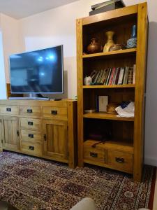 un televisor sentado en un centro de entretenimiento de madera en Homely Home en Buckinghamshire