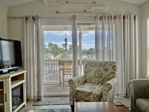 a living room with a chair and a television at 26i WWV Myrtle Beach Intracoastal Waterway Gem in Myrtle Beach