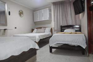 里奧阿查的住宿－HOTEL PRIMAVERA RIOHACHA，客房设有两张床和一台平面电视。