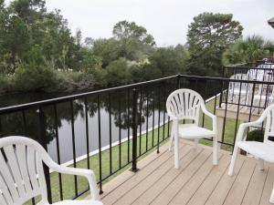 drie witte stoelen op een terras met uitzicht op een rivier bij Deerfield Plantation 217A2 in Myrtle Beach