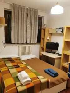 1 dormitorio con 1 cama, escritorio y ordenador en Luminoso e accogliente appartamento a San Donato, en San Donato Milanese