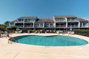 a large house with a swimming pool in front of a building at 1J Golf Colony Resort in Family Friendly Surfside in Myrtle Beach