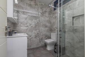 a bathroom with a toilet and a glass shower at Avithos Blue Villas in Svoronata