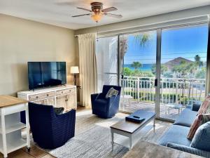 a living room with a couch and a television and a balcony at Cabana's @ Gulf Place #308 in Santa Rosa Beach