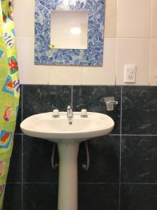 W łazience znajduje się biała umywalka i lustro. w obiekcie El Descanso Housse II w mieście San Miguel de Tucumán
