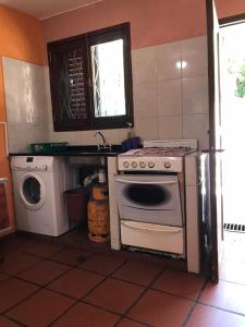 a kitchen with a stove and a washing machine at El Descanso Housse II in San Miguel de Tucumán