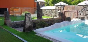 una piscina en un patio con una pared de piedra en El Pinar en Icod de los Vinos