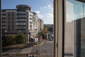 una finestra con vista su una strada della città di Lion's Unirii Apartment a Bucarest