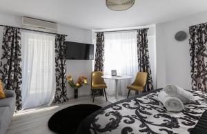 a bedroom with a bed and a table and chairs at Lion's Unirii Apartment in Bucharest