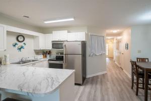 uma cozinha com um frigorífico de aço inoxidável e uma mesa em Golf Colony Resort 36F em Myrtle Beach