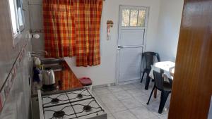 cocina pequeña con fogones y ventana en El Depto de la Abuela en Puerto Iguazú