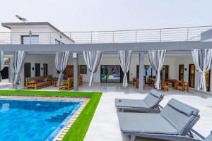 uma villa com uma piscina e espreguiçadeiras em ChezBabo Wellness Hotel em Ngaparou