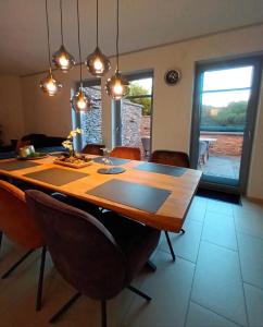 uma sala de jantar com uma mesa de madeira e cadeiras em Attraktive Wohnung-Elztalidyll-zwischen Mosel,Nürburgring und Burg Eltz em Kollig