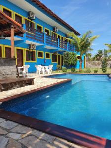 a house with a swimming pool in front of it at Pousada Retiro das Caravelas in Cananéia
