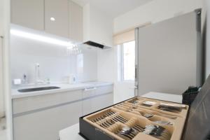 an empty kitchen with white cabinets and a counter at NISEKO EPIC HOUSE in Niseko