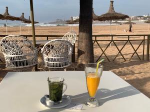 una mesa con dos bebidas en la parte superior de la playa en Appartement très Haut standing vue sur mer à Mohammedia, en Mohammedia