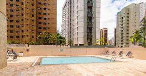 a swimming pool in the middle of a city with tall buildings at Apart Hotel Volpi in Belo Horizonte