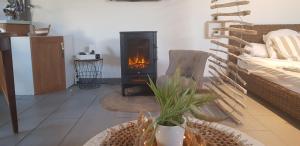 a fireplace in a living room with a stove at Le Studio 1044 in Le Crotoy