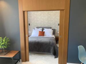 B-LIVING LUXURY APARTMENTS في الدار البيضاء: غرفة نوم بسرير مع باب مفتوح