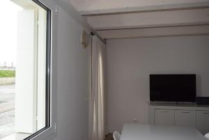 a white room with a tv and a window at Villa AMARE in Caorle