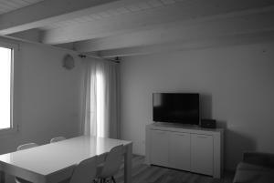 a living room with a table and a flat screen tv at Villa AMARE in Caorle