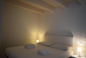 a bedroom with a white bed with two towels on it at Villa AMARE in Caorle