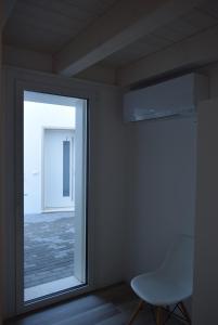 a white chair in a room with a window at Villa AMARE in Caorle