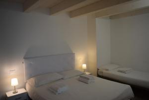 two beds in a room with two lamps on them at Villa AMARE in Caorle