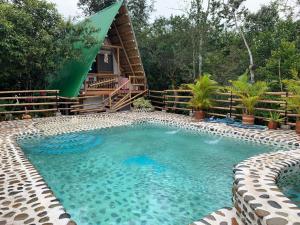 a large swimming pool in front of a log cabin at Villa Anita - Acuérdate de Mi. in Neiva
