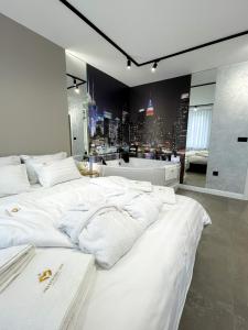 two white beds in a room with a view of a city at President Lux Apartment in Pale