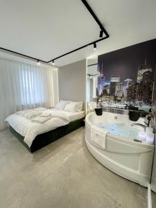 sypialnia z wanną obok łóżka i łazienka w obiekcie President Lux Apartment w mieście Pale