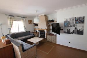 ein Wohnzimmer mit einem Sofa und einem TV in der Unterkunft CHALET CON PISCINA A 100m DE LA PLAYA LA MANGA in La Manga del Mar Menor
