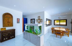 a dining room with a fish tank and a dining table at ChezBabo Wellness Hotel in Ngaparou