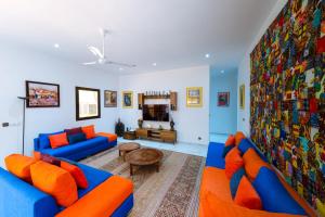 sala de estar con sofás azules y almohadas de color naranja en ChezBabo Wellness Hotel en Ngaparou