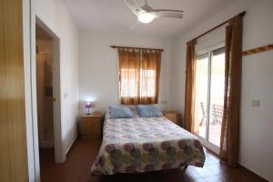 1 dormitorio con cama y ventana en CHALET CON PISCINA A 100m DE LA PLAYA LA MANGA, en La Manga del Mar Menor