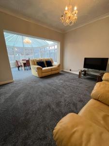 uma sala de estar com um sofá e uma televisão de ecrã plano em 19A Stourwood Avenue em Southbourne