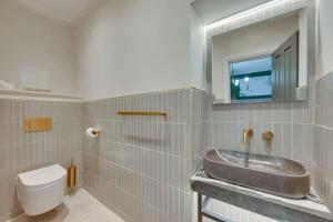 ein Bad mit einem Waschbecken und einem WC sowie einen TV in der Unterkunft Newly renovated 4 Bedroom Cottage with Wood Burner in Aysgarth + 29 Fotos