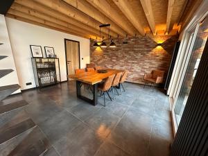 jadalnia z drewnianym stołem i ceglaną ścianą w obiekcie LFA Magnifique loft véritable avec sauna w mieście Flémalle-Grande