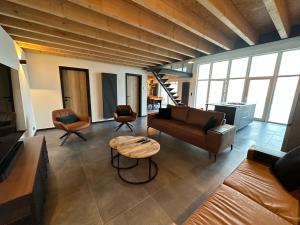 a living room with a couch and a table at LFA Magnifique loft véritable avec sauna in Flémalle-Grande