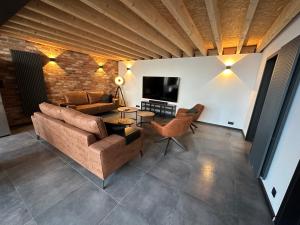 uma sala de estar com um sofá e uma televisão em LFA Magnifique loft véritable avec sauna em Flémalle-Grande