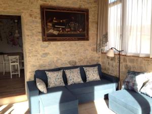 a living room with a blue couch and a painting on the wall at FAETOLE typical Tuscan country house near FLORENCE in Capannuccia